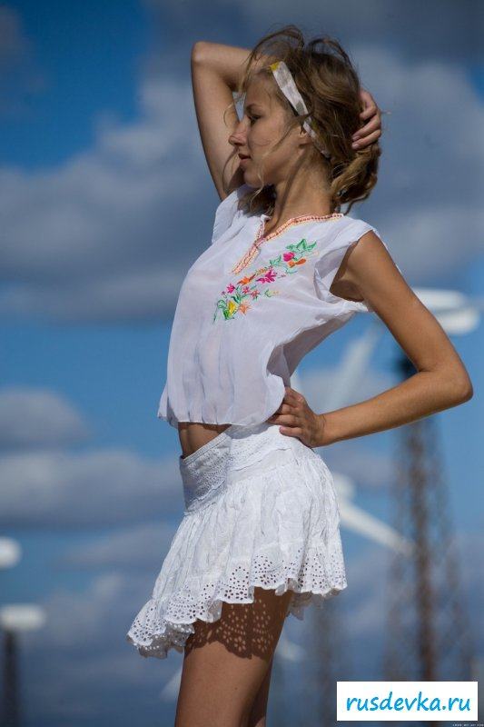 Прогулка раздевающейся девчушки среди ветряков